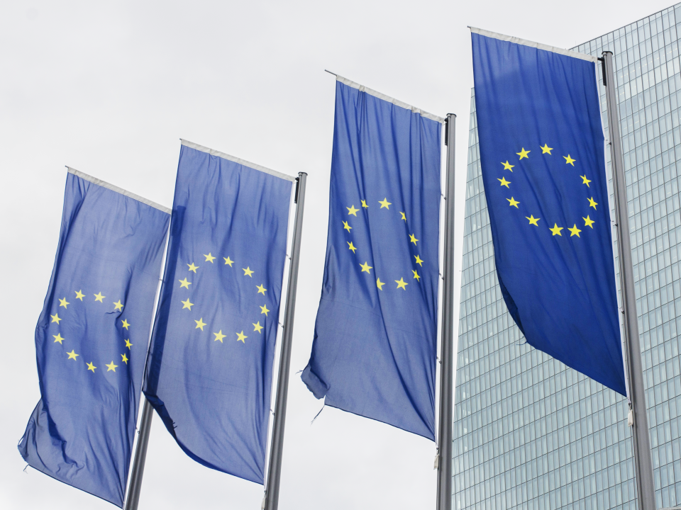 Four EU flags flying in front of a building