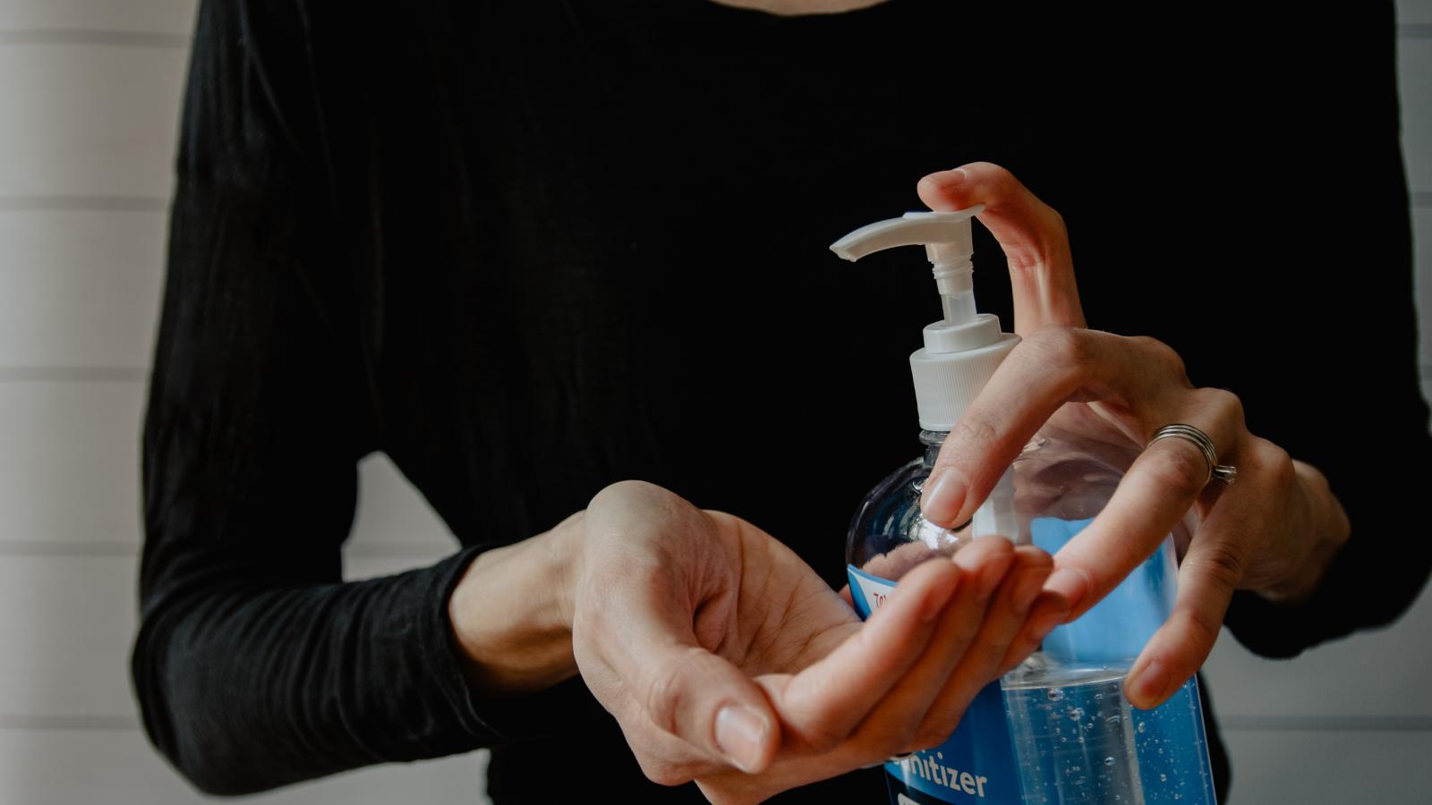 Person cleaning their hands with hand sanitiser
