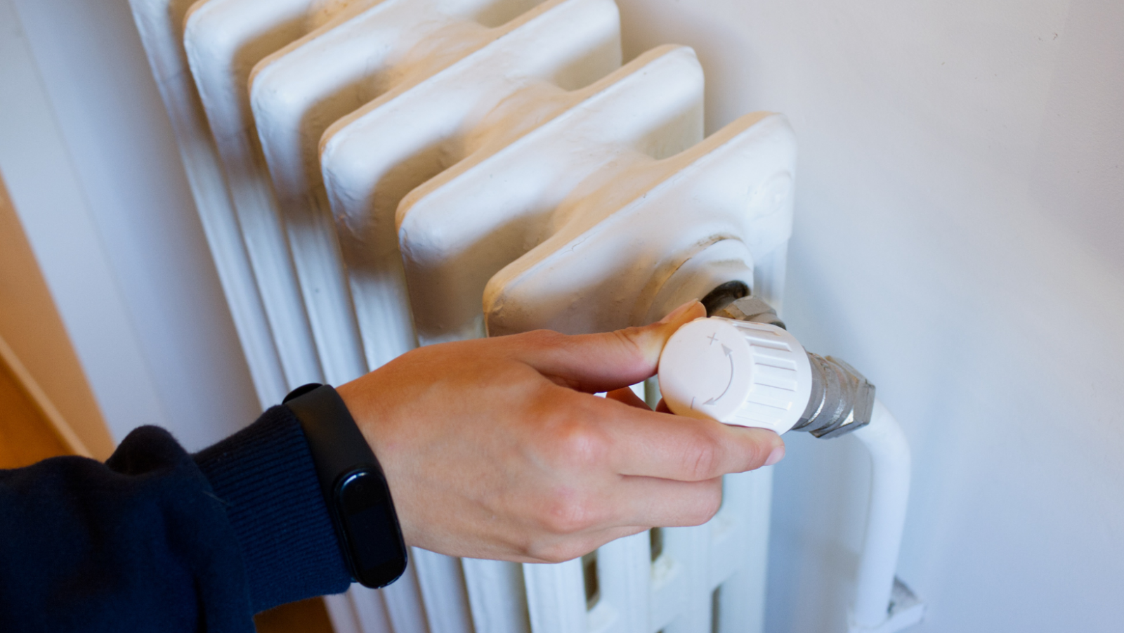 Hand adjusts setting on radiator