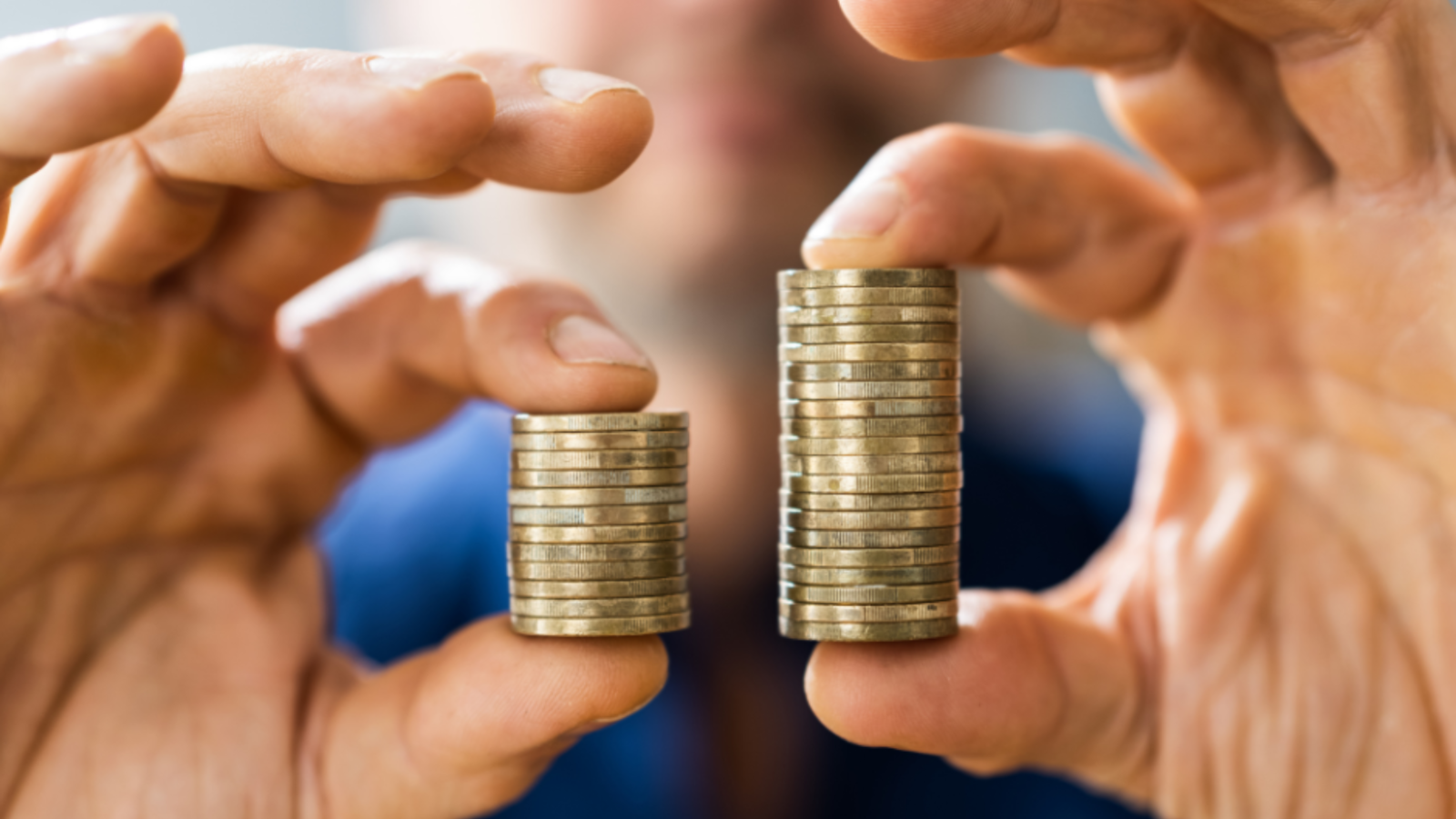 Man holding coins in his hands, one side is bigger than the other