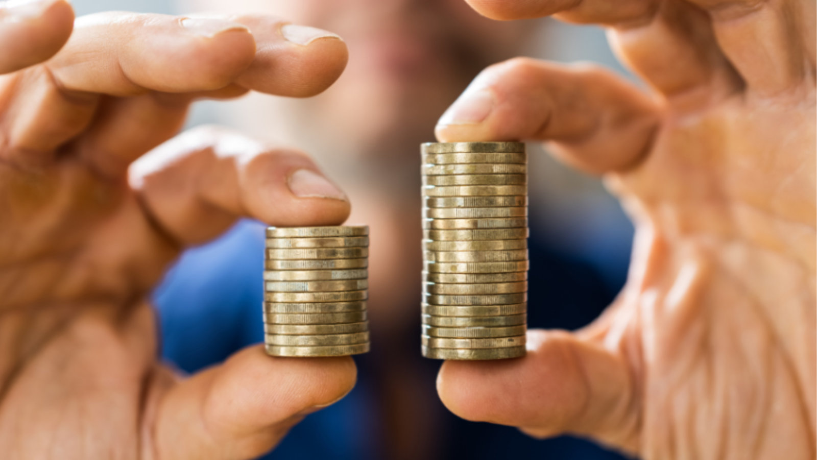 Man holding coins in his hands, one side is bigger than the other