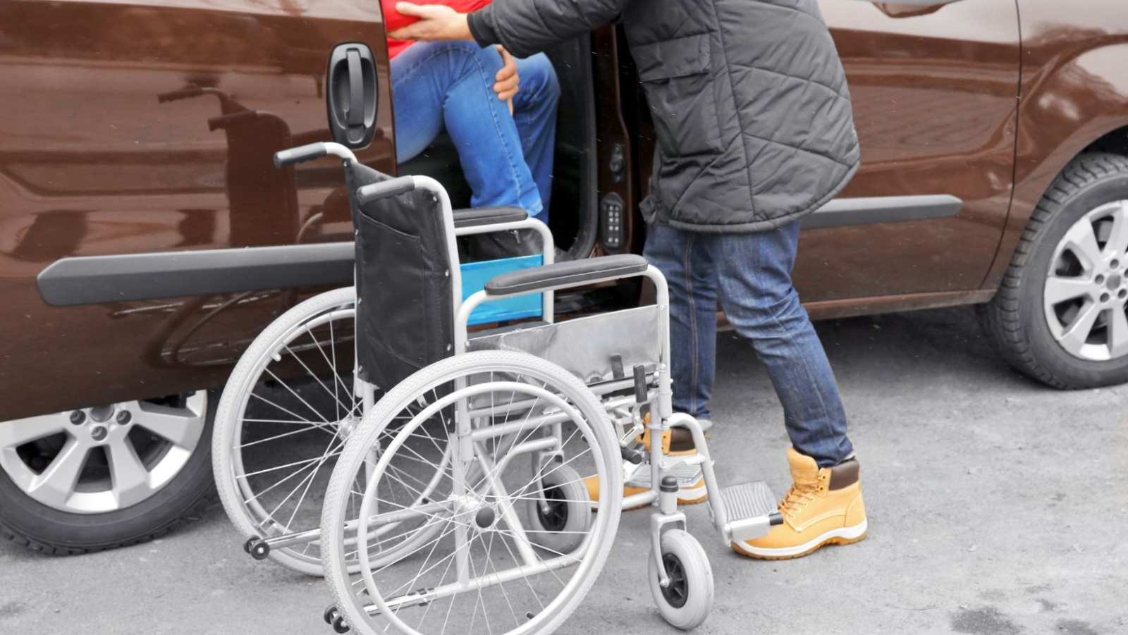 carer assisting someone from a wheelchair