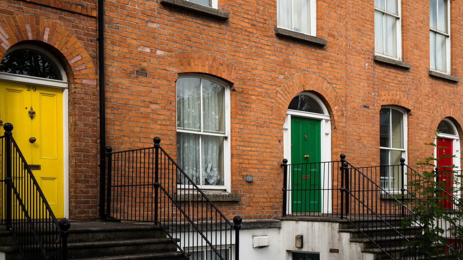 Red brick Georgian houses in Ireland with steps leading up to them.