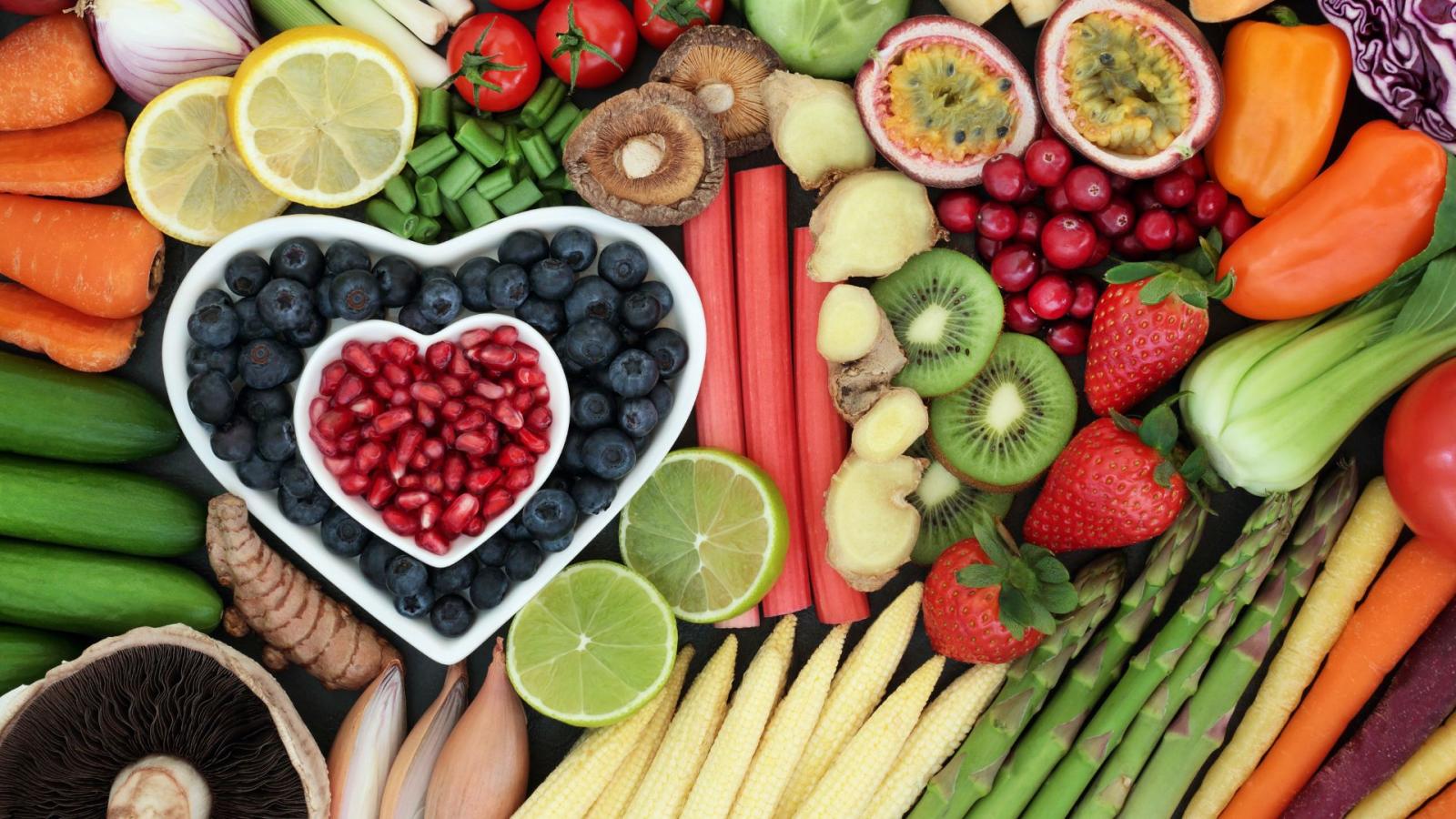 A selection of fruit, vegetables and berries laid out on a flat surface
