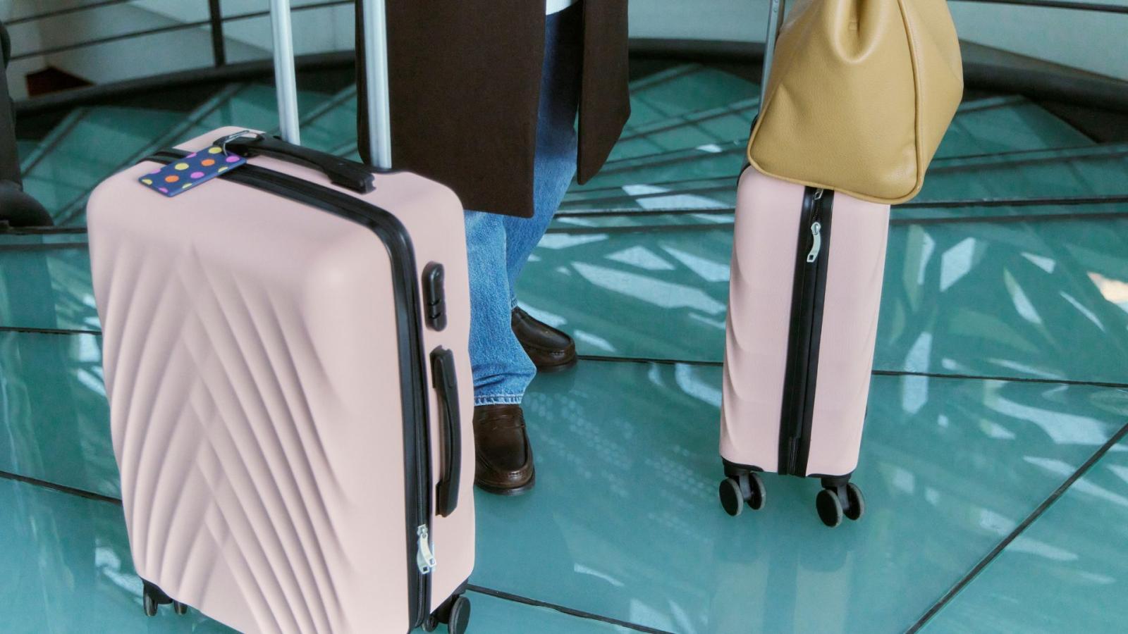 Two pink suitcases belonging to a woman in an airport
