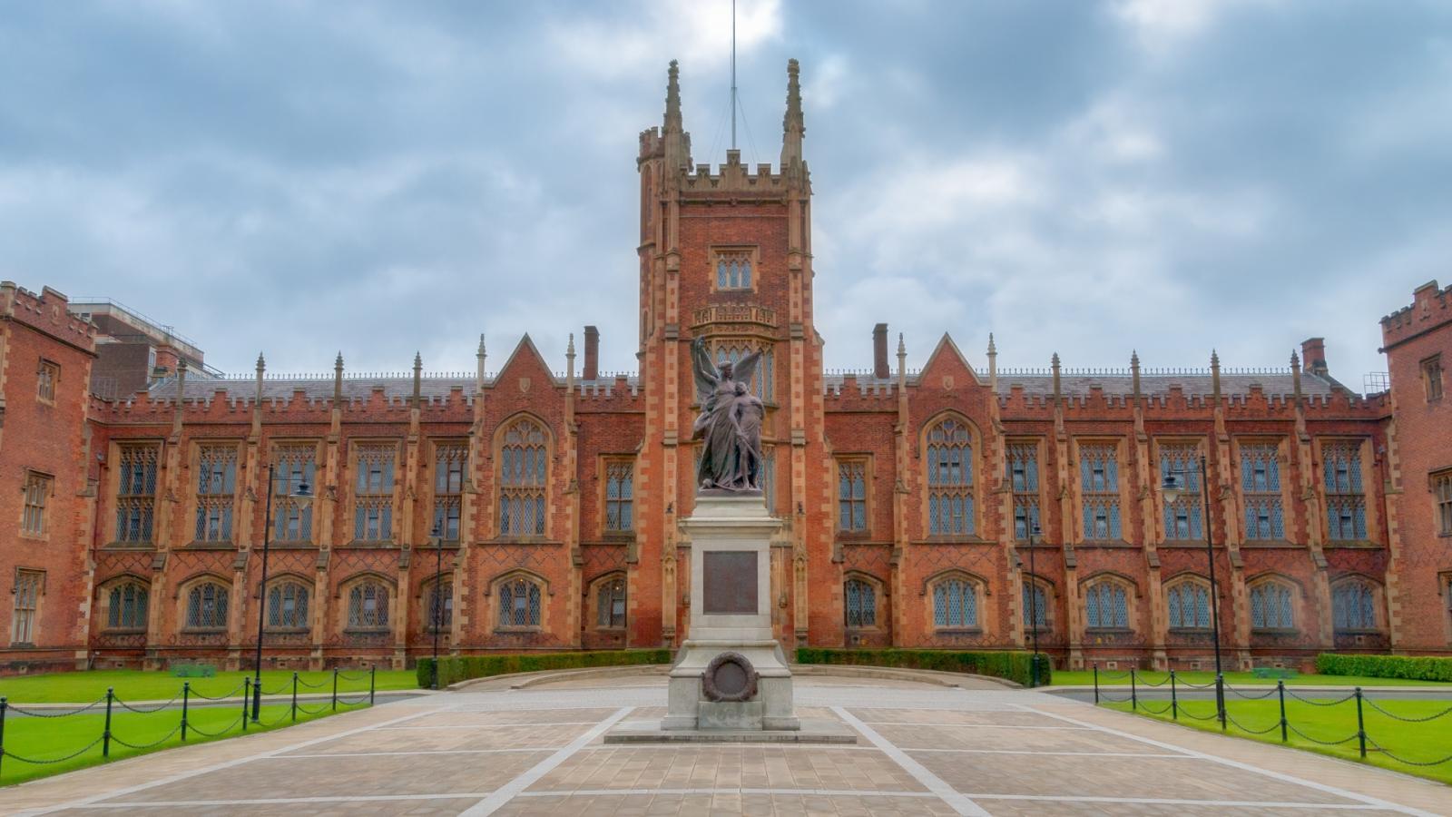 An exterior image of Queens University Belfast, a grand red brick building with a statue in the courtyard